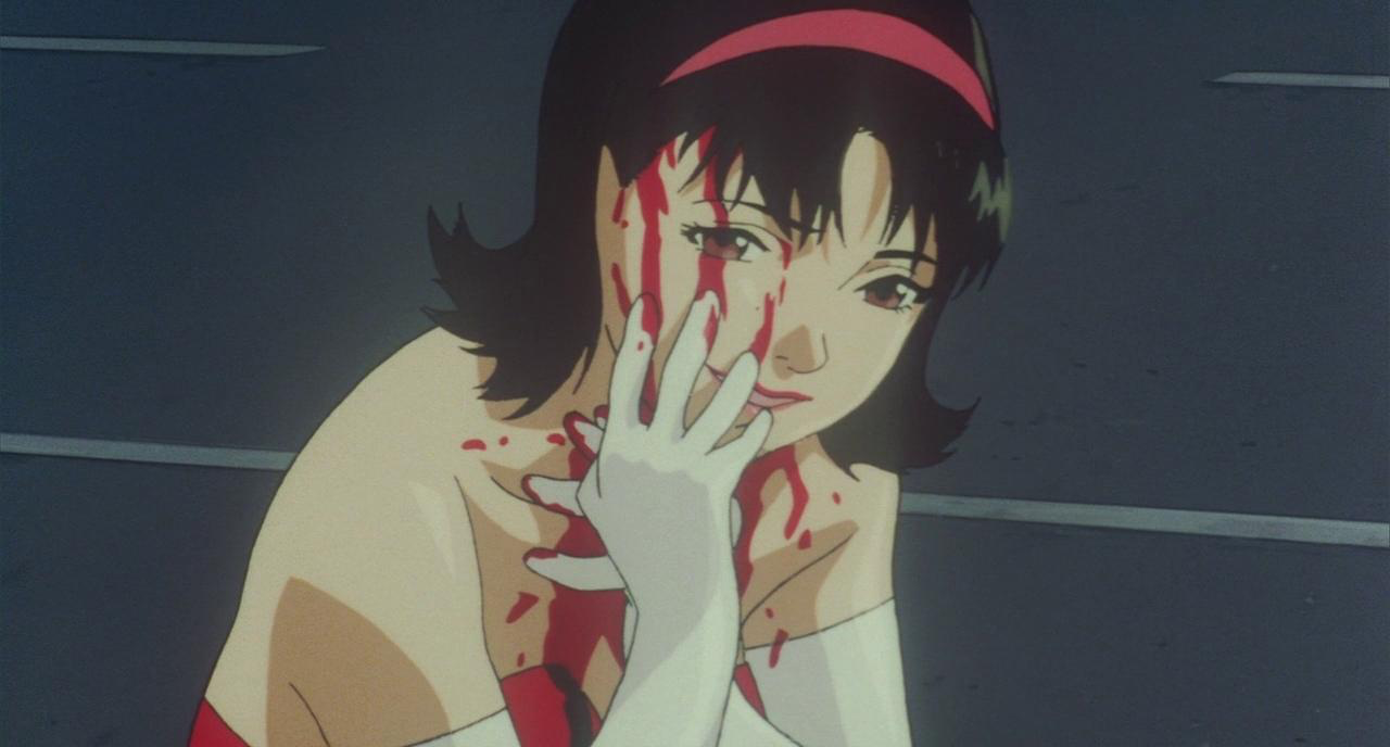 Mima with her hand and blood on her face